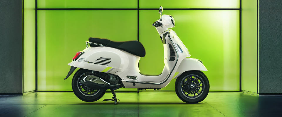 Persona disfrutando de conducir una moto Vespa por la ciudad